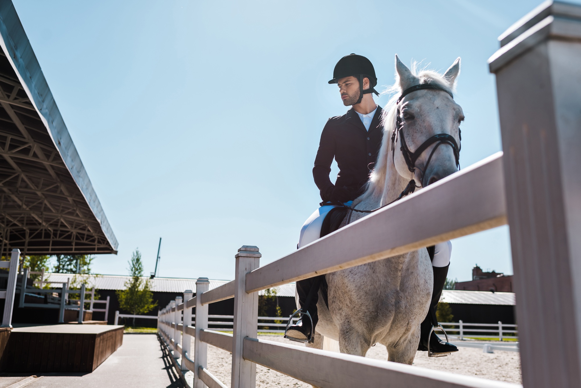 bel homme à cheval près d'une clôture dans un club hippique